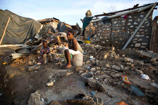 A woman and child sit amidst the rubble left in Jeremie, Haiti in wake of Hurricane Matthew. Image: Dieu Nalio Chery/AP